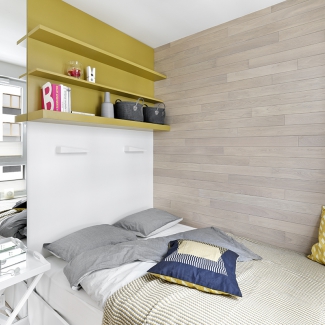 Mała sypialnia z drewnem na ścianie
